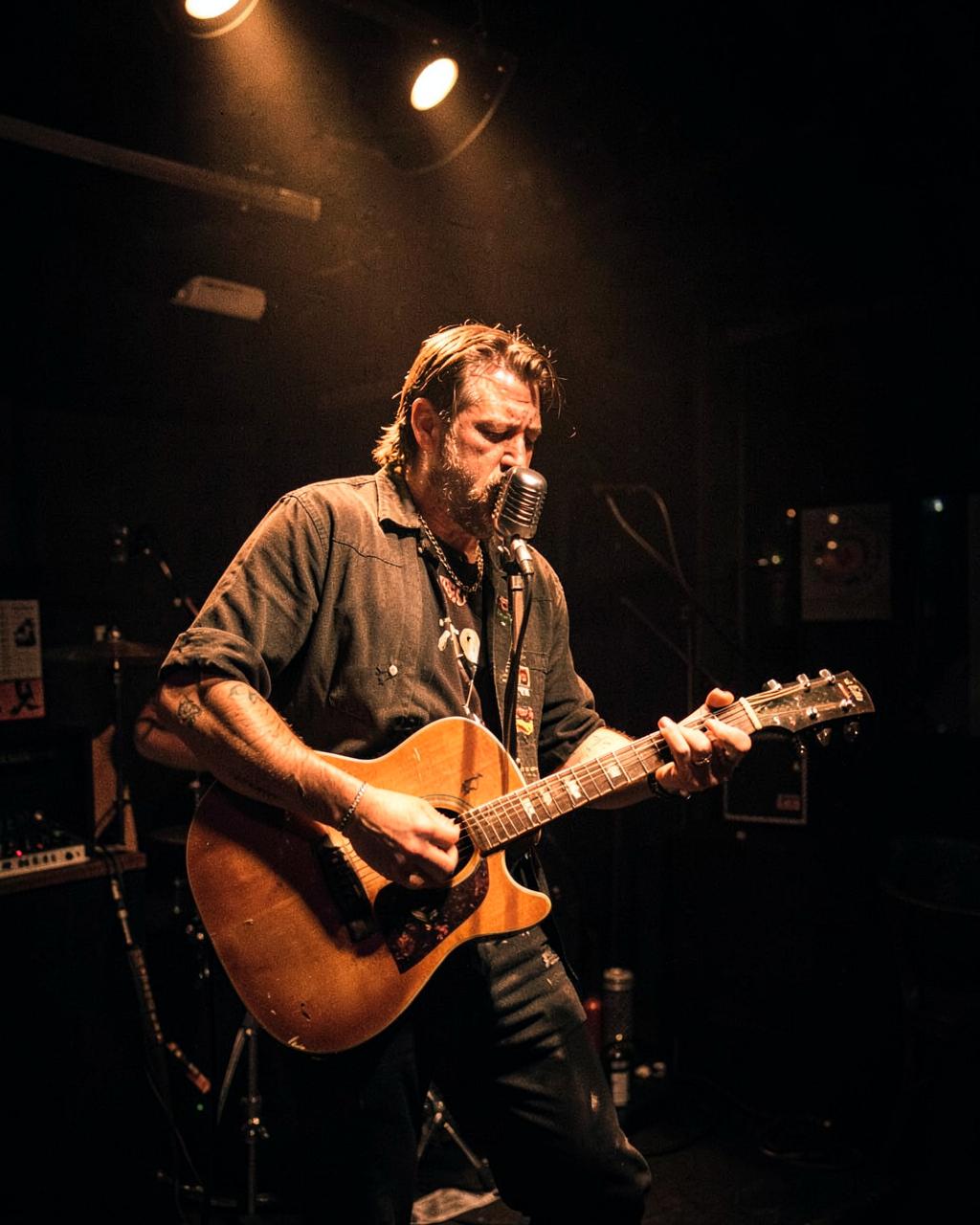 Trubadur med gitar på liten scene